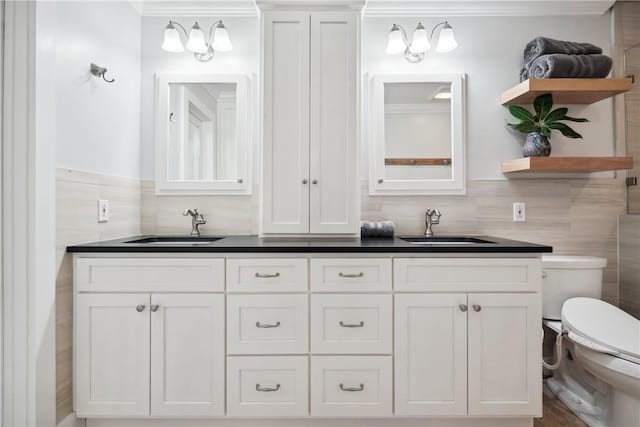 bathroom with vanity, tile walls, and toilet