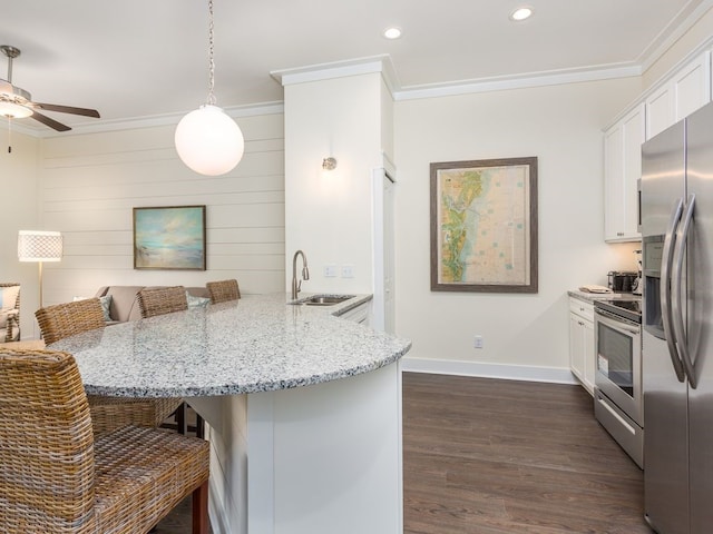 kitchen with a breakfast bar, sink, white cabinetry, and hanging light fixtures