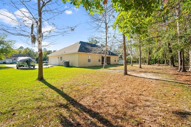 exterior space with a garage and central AC