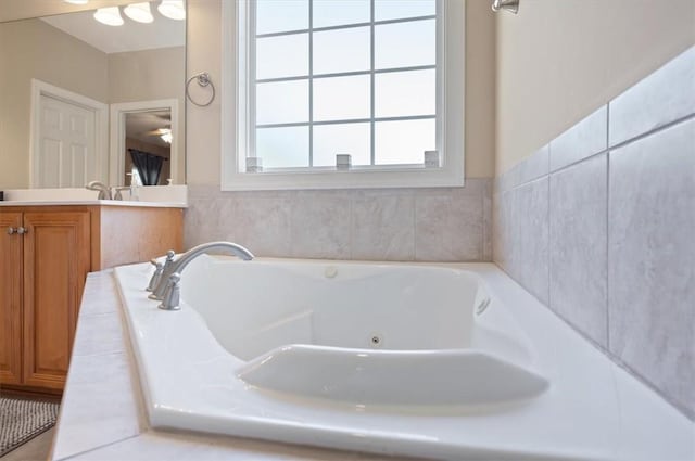 bathroom featuring vanity and tiled bath