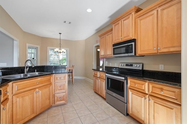 kitchen featuring dark stone counters, stainless steel appliances, sink, decorative light fixtures, and a chandelier