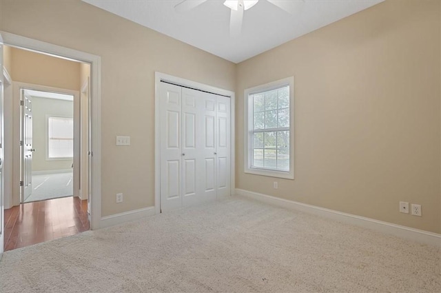 unfurnished bedroom featuring carpet flooring, ceiling fan, and a closet