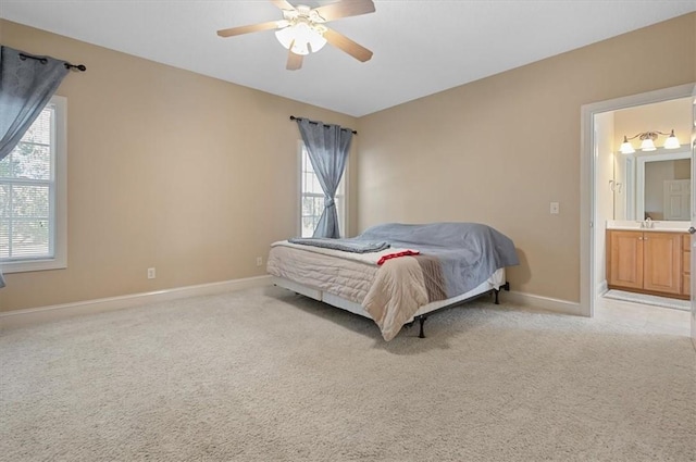 carpeted bedroom with sink, connected bathroom, multiple windows, and ceiling fan