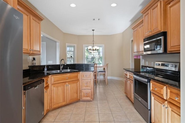 kitchen featuring sink, hanging light fixtures, a chandelier, light tile patterned floors, and appliances with stainless steel finishes