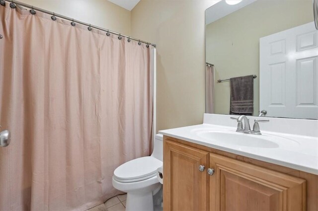 bathroom featuring tile patterned flooring, vanity, a shower with shower curtain, and toilet