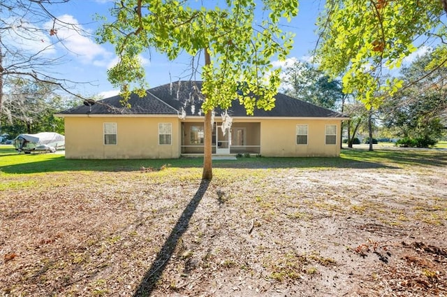 rear view of property with a yard and a sunroom