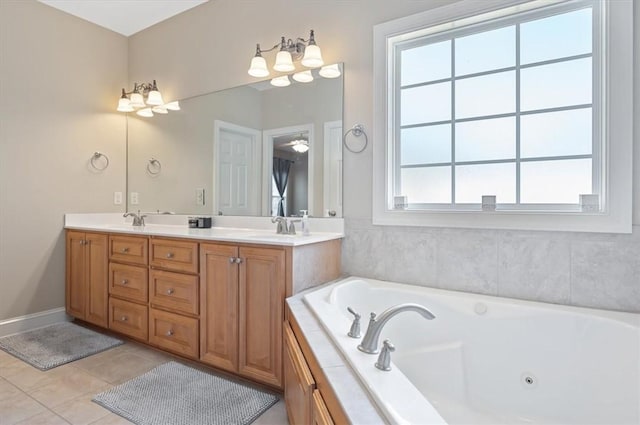 bathroom with tiled tub, tile patterned flooring, vanity, and a healthy amount of sunlight