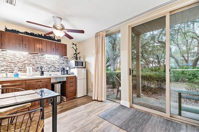 kitchen featuring tasteful backsplash, ceiling fan, white fridge, and light hardwood / wood-style floors