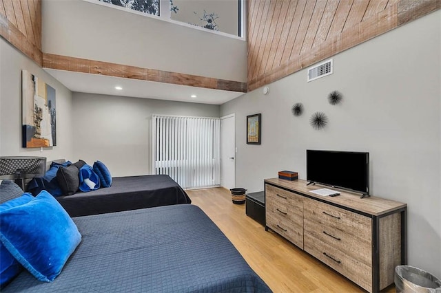 bedroom with a towering ceiling and light wood-type flooring