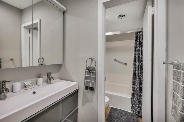 full bathroom with shower / bath combination with curtain, vanity, and toilet