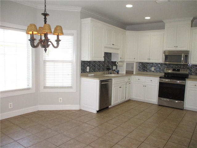 kitchen with sink, hanging light fixtures, white cabinetry, stainless steel appliances, and a chandelier