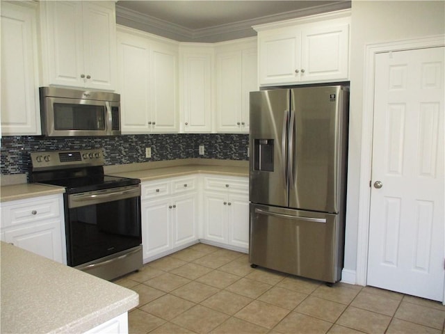 kitchen with white cabinets, light tile patterned floors, crown molding, and appliances with stainless steel finishes