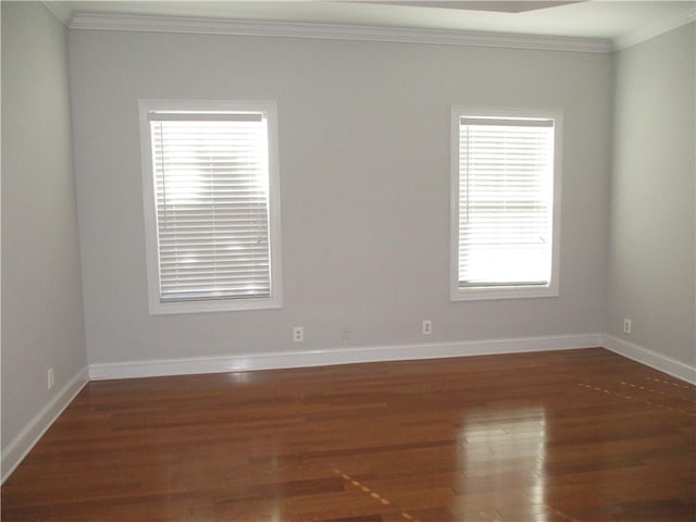 spare room with dark wood-type flooring and ornamental molding