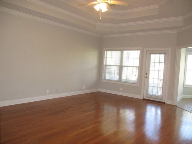 unfurnished room with hardwood / wood-style floors, ceiling fan, a raised ceiling, and crown molding