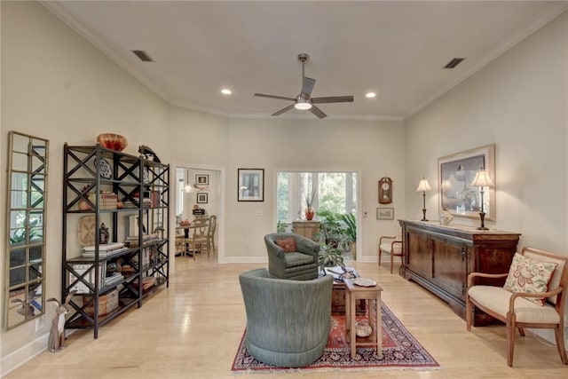 living room featuring ceiling fan, crown molding, and light wood-type flooring