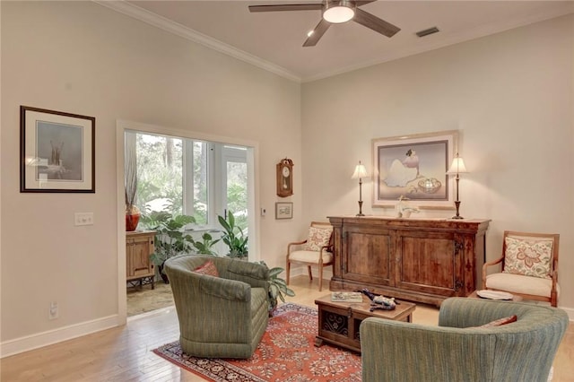 sitting room featuring ceiling fan, ornamental molding, and light wood-type flooring