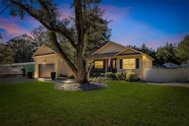 ranch-style home featuring a lawn and a garage