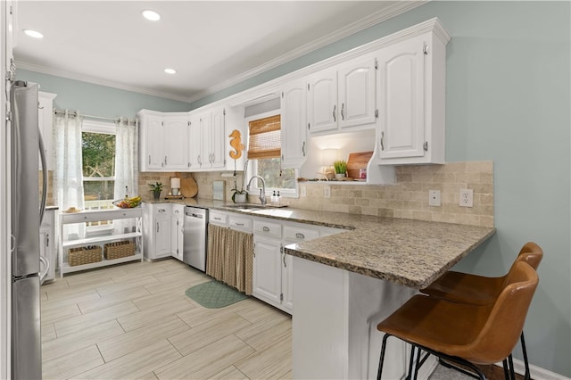 221 River Ridge Rd, Brunswick, GA 31523 - kitchen featuring a sink, white cabinets, stainless steel appliances, and a peninsula