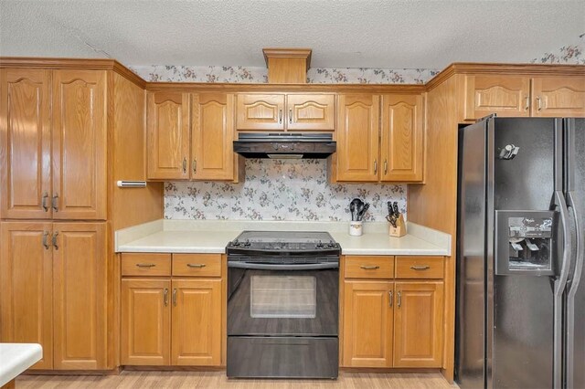 1056 Fiddler Trce, Townsend, GA 31331 - kitchen featuring black appliances, extractor fan, a textured ceiling, light countertops, and brown cabinetry