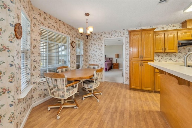 1056 Fiddler Trce, Townsend, GA 31331 - dining space with wallpapered walls, light wood-style flooring, and a chandelier