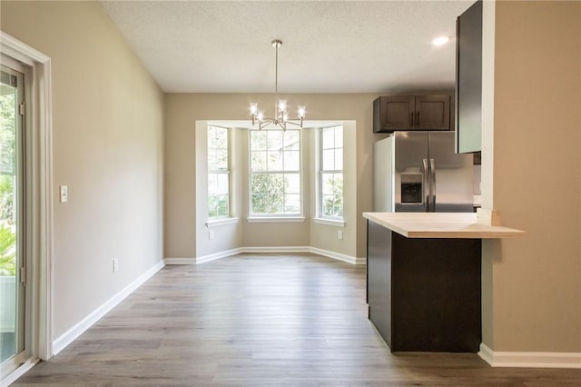 104 Bamboo Dr, Kingsland, GA 31548 - kitchen featuring stainless steel refrigerator with ice dispenser, plenty of natural light, a chandelier, wood finished floors, and a textured ceiling