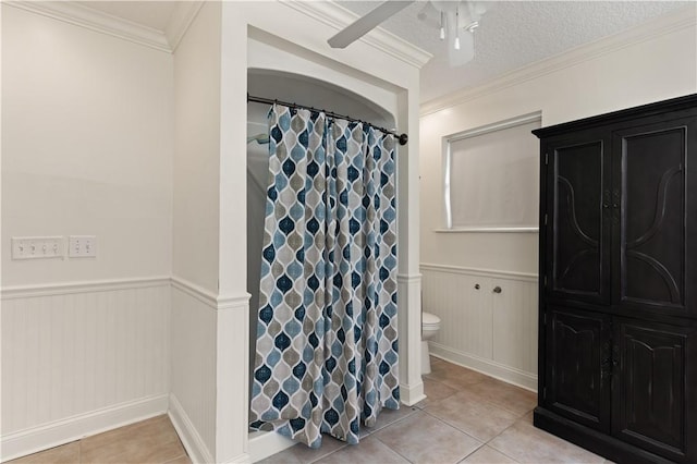 bathroom with tile patterned floors, toilet, a textured ceiling, and ornamental molding