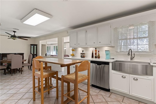 kitchen with ceiling fan, dishwasher, sink, light tile patterned floors, and white cabinets