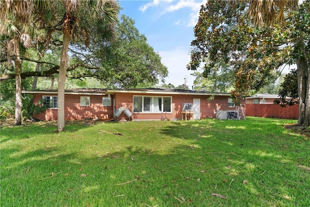 view of front of property with brick siding, fence, and a front yard