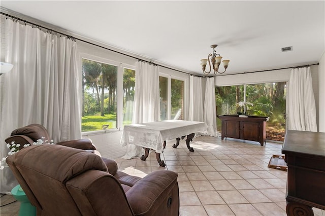 sunroom featuring plenty of natural light, pool table, and a chandelier