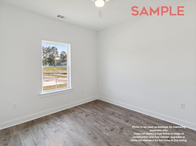 spare room with hardwood / wood-style floors and ceiling fan