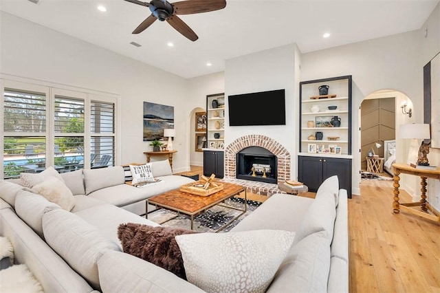 kitchen with hanging light fixtures, white cabinets, a center island, wall chimney range hood, and stainless steel appliances