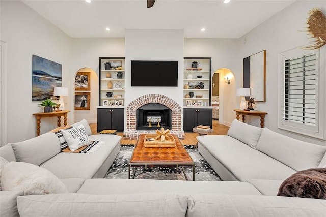 kitchen featuring pendant lighting, wall chimney exhaust hood, white cabinetry, stove, and a kitchen island