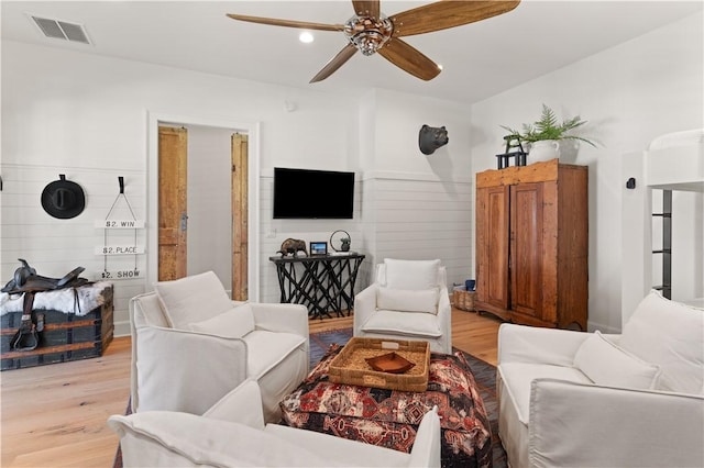 living room with ceiling fan and light hardwood / wood-style flooring