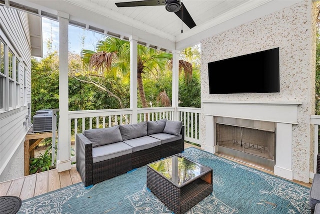 sunroom / solarium featuring ceiling fan, exterior fireplace, and wood ceiling