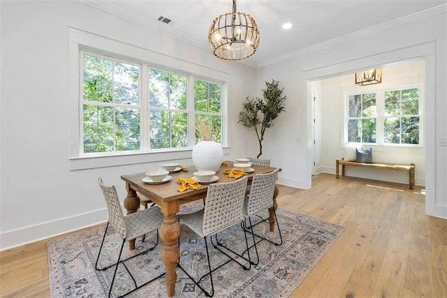 living room with ceiling fan with notable chandelier, ornamental molding, and light hardwood / wood-style flooring