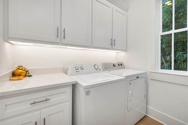 laundry room featuring washer and dryer and cabinets