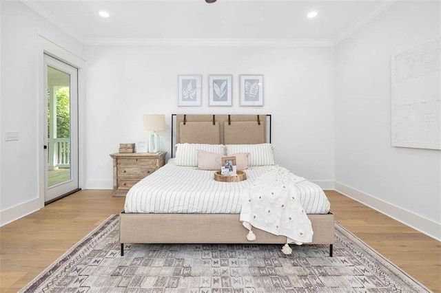 bedroom featuring hardwood / wood-style floors, crown molding, and access to outside