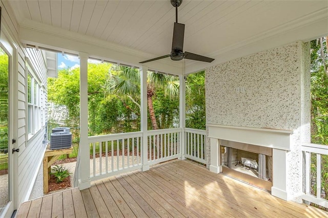 unfurnished sunroom featuring a fireplace and ceiling fan