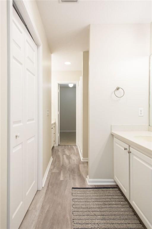 200 Salt Air Dr Unit 139, Saint Simons Island, GA 31522 - hallway featuring baseboards, light wood-type flooring, a sink, and recessed lighting