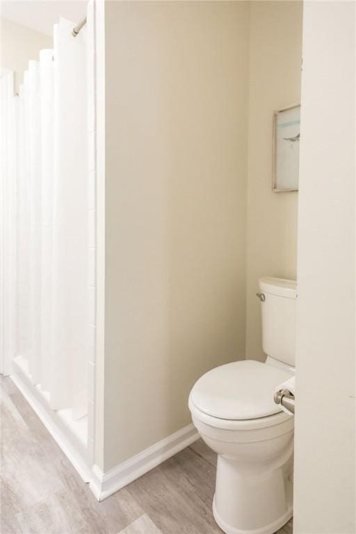 200 Salt Air Dr Unit 139, Saint Simons Island, GA 31522 - bathroom featuring a stall shower, toilet, wood finished floors, and baseboards
