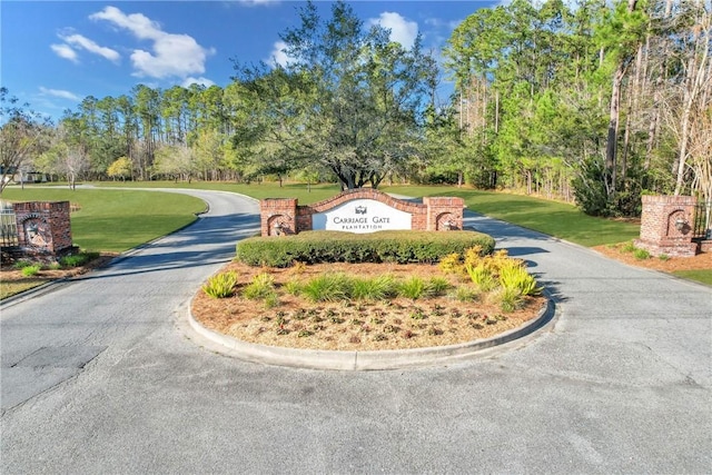 64 Wellington Cir, Brunswick, GA 31525 - community / neighborhood sign with driveway, a yard, and view of wooded area