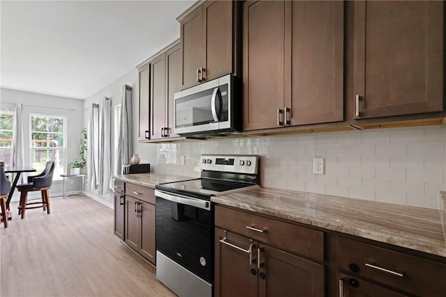 64 Wellington Cir, Brunswick, GA 31525 - kitchen with appliances with stainless steel finishes, light wood finished floors, backsplash, light stone counters, and dark brown cabinetry