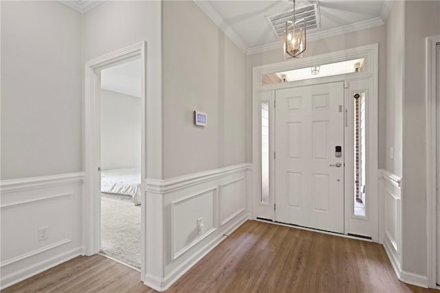 64 Wellington Cir, Brunswick, GA 31525 - entrance foyer featuring wood finished floors, a decorative wall, ornamental molding, and wainscoting