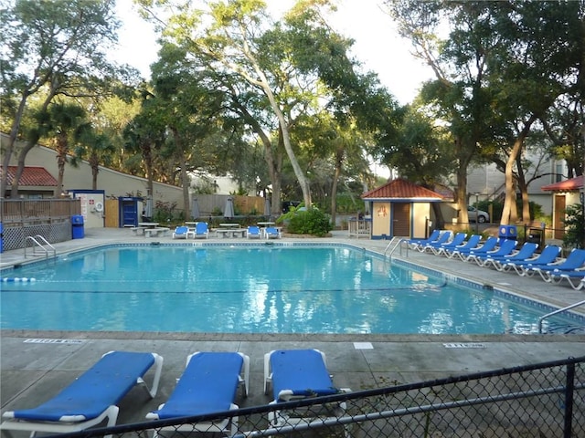 community pool with fence and a patio area