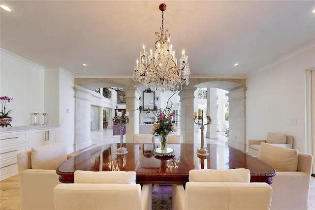 dining room featuring a notable chandelier, light wood-type flooring, ornamental molding, and ornate columns