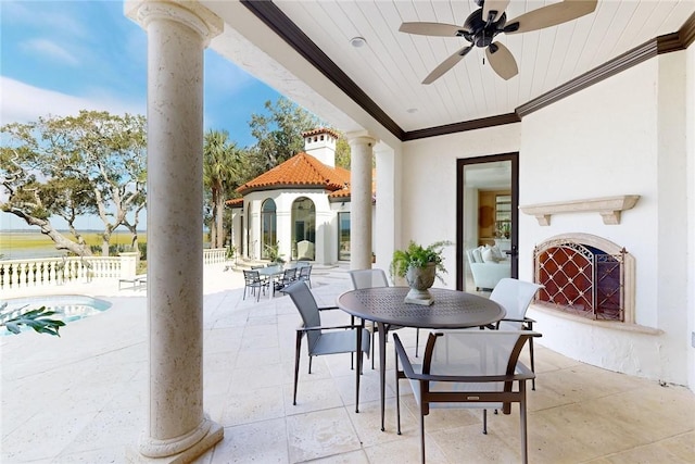 view of patio / terrace with ceiling fan and exterior fireplace