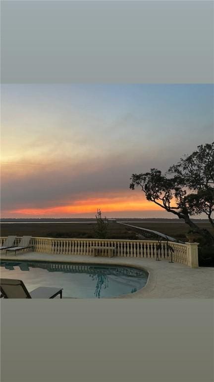 pool at dusk with a patio