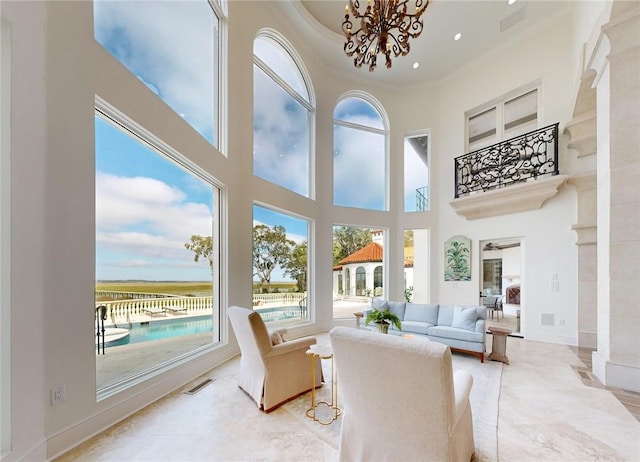 sunroom / solarium featuring a notable chandelier