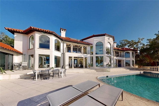 back of property with a balcony and a patio area