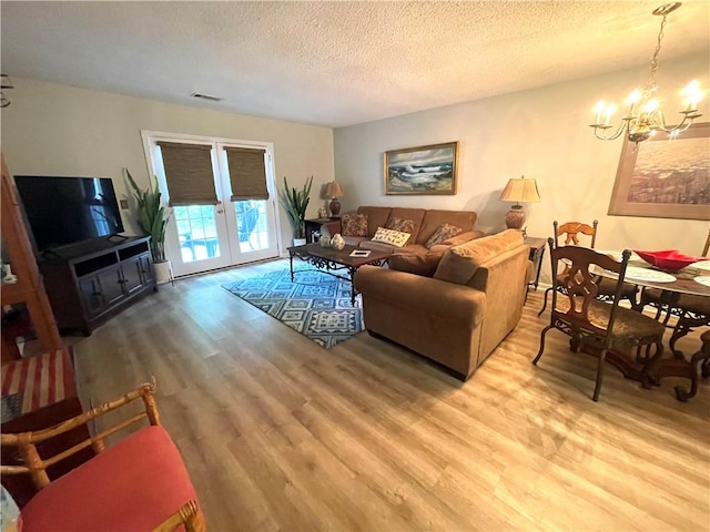 622 Brockinton Pt, Saint Simons Island, GA 31522 - living area with wood finished floors, french doors, a chandelier, and a textured ceiling